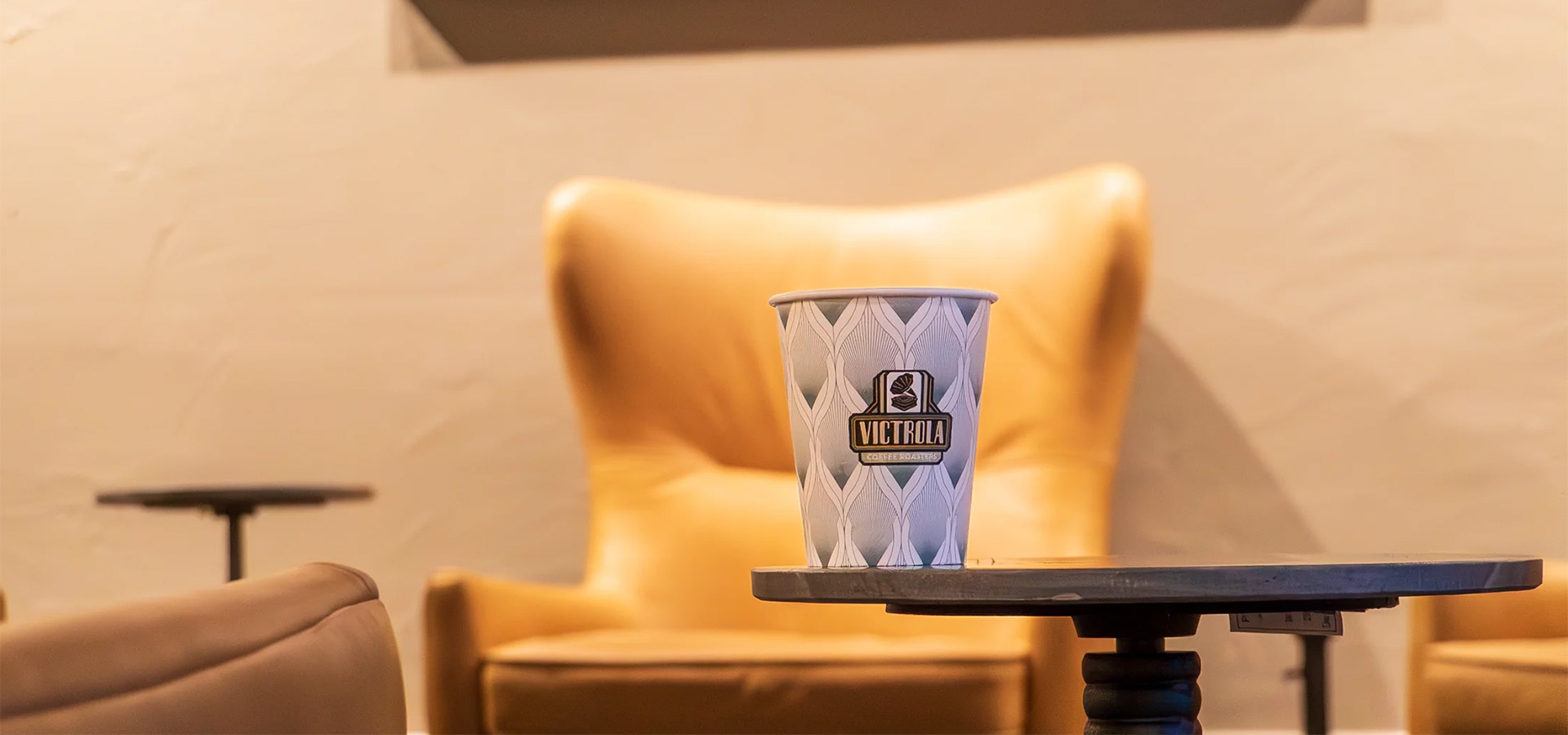 coffee cup on table with chair in background