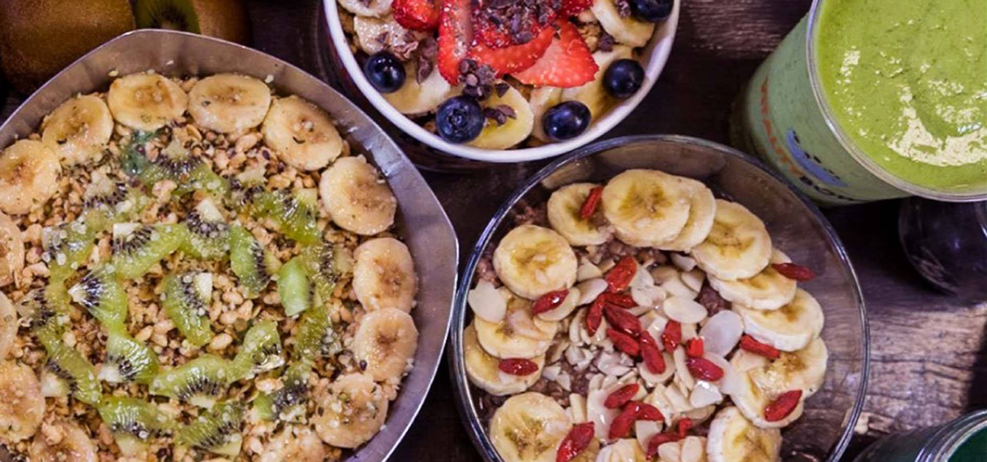 Table with acai and fruit bowls on it