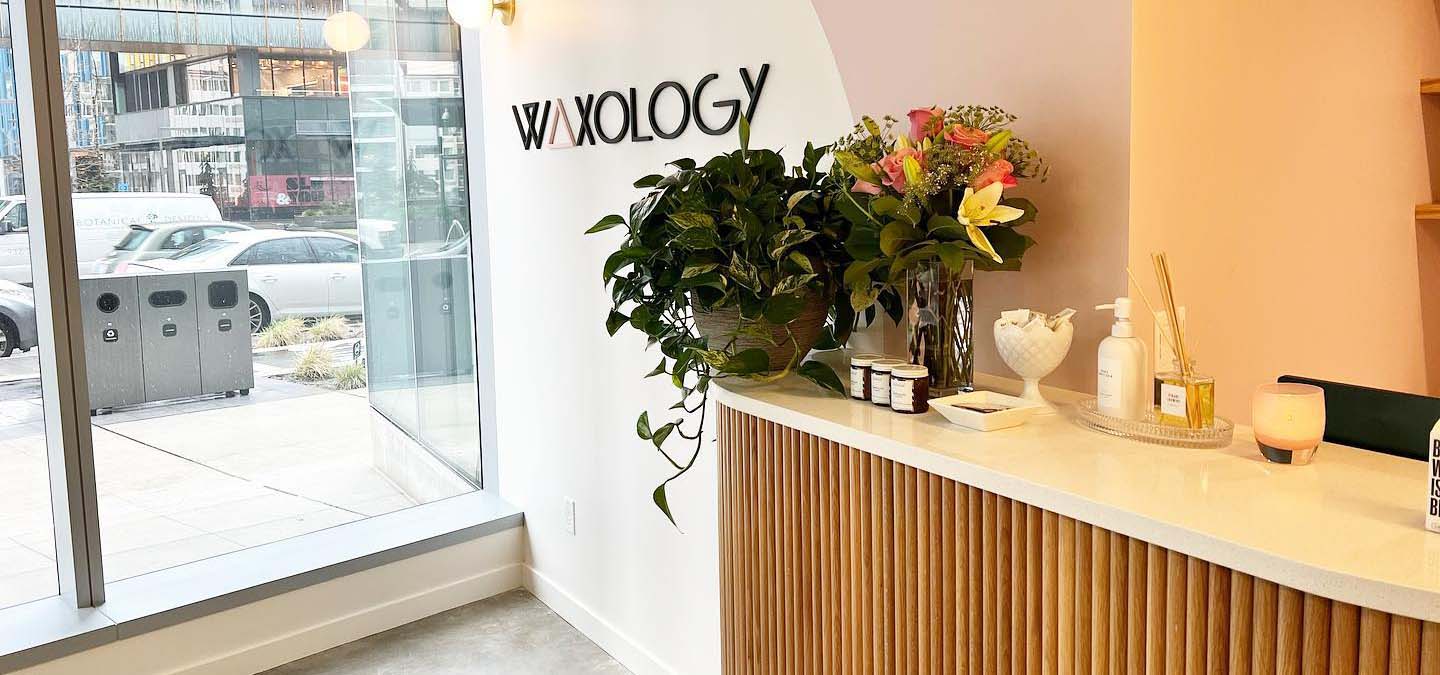 Lobby of a waxing salon with flowers on the front desk.