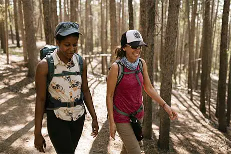 two women walking in woods