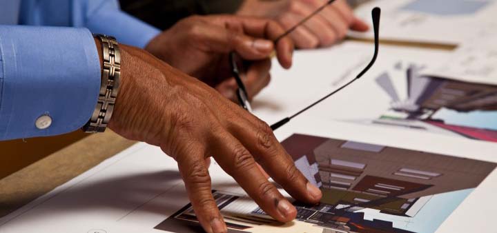Hand pressing down on papers in conversation to demonstrate what they are talking about.