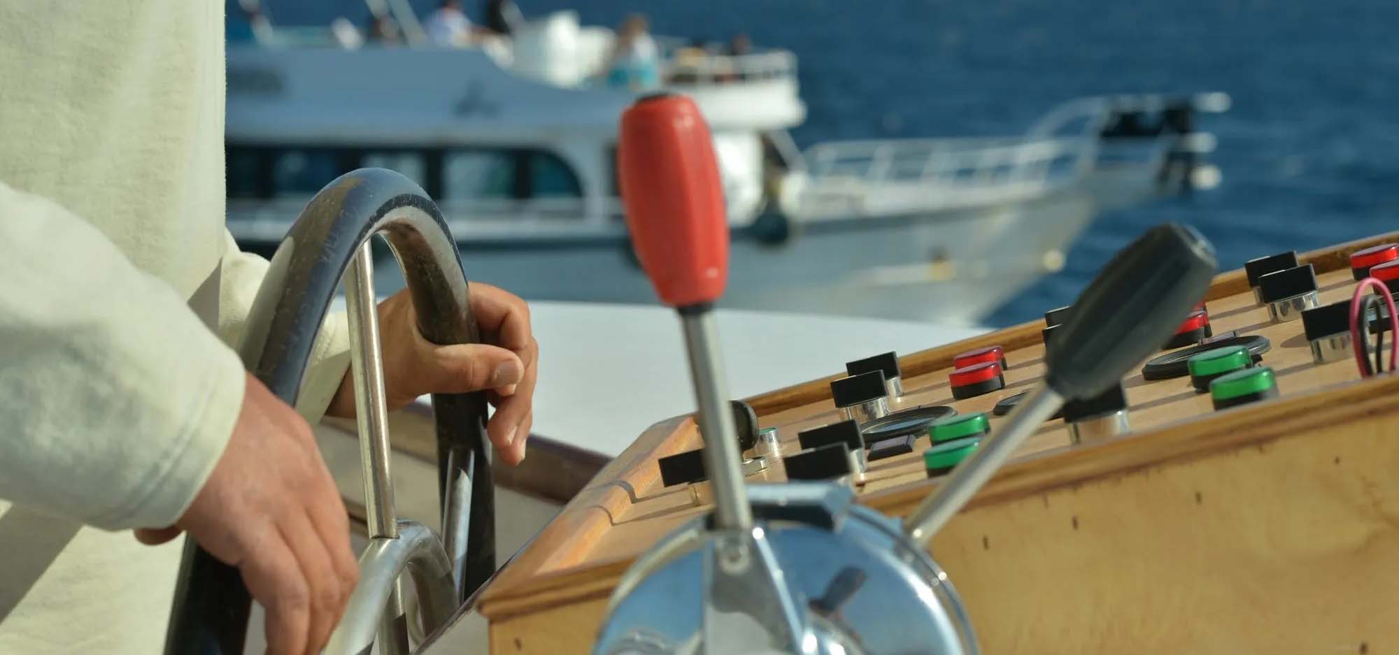 Photos of hand steering a boat at the helm.