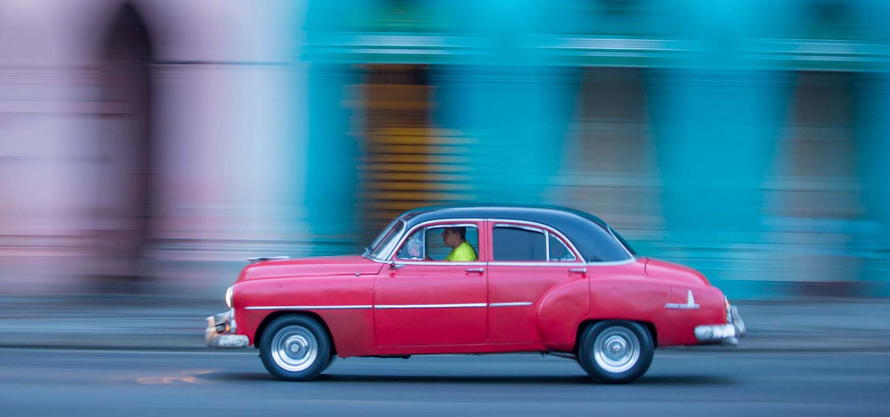 A red car driving.