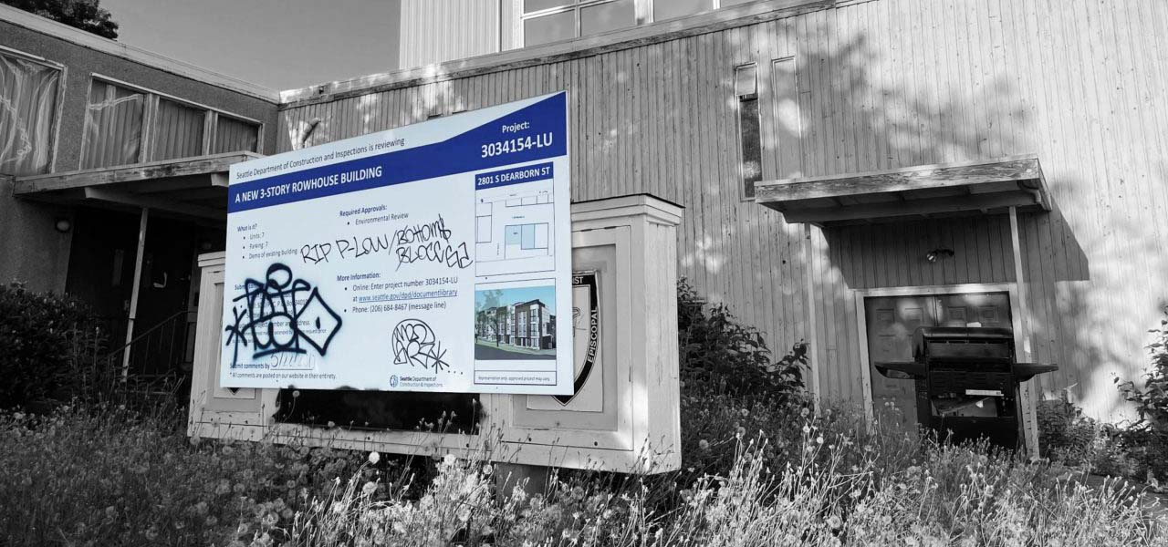 Condemned building with a proposed construction sign in front.