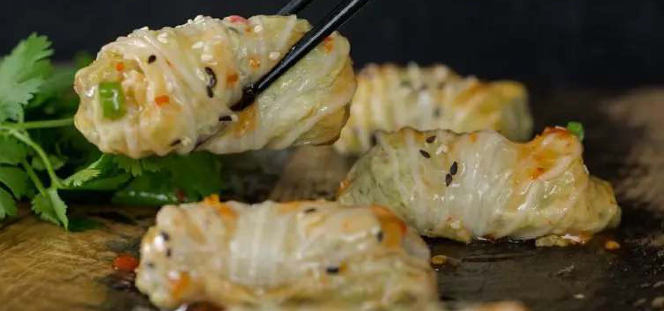 Chicken cabbage dumplings with sweet chili sauce drizzled on top.