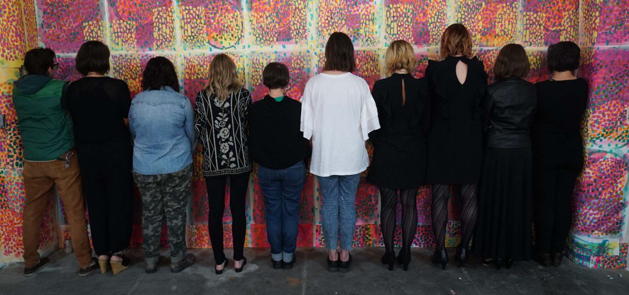 Rear view of a performance art troupe standing together.