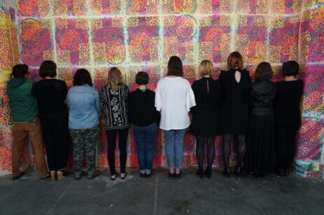 Rear view of a performance art troupe standing together.