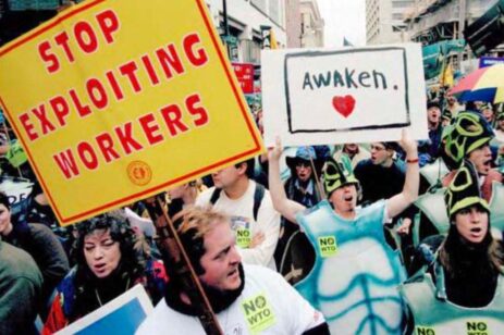 Protesters marching and holding signs for workers rights.