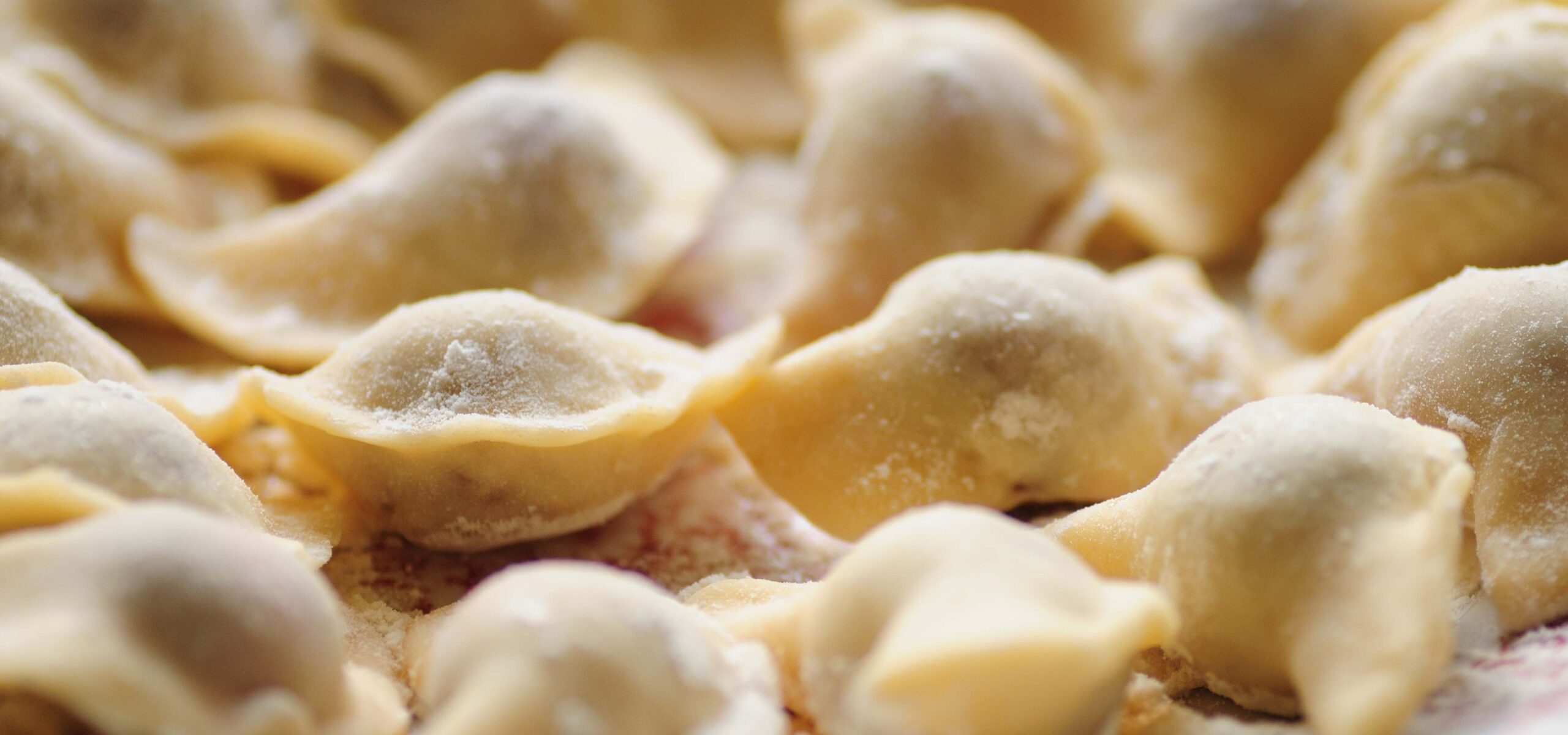 Close up view of pierogis drying on a tray.