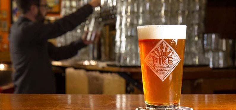 A pint of beer on a counter.