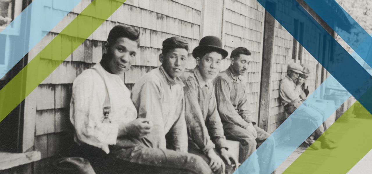 Old photo of Asian workers on a bench.