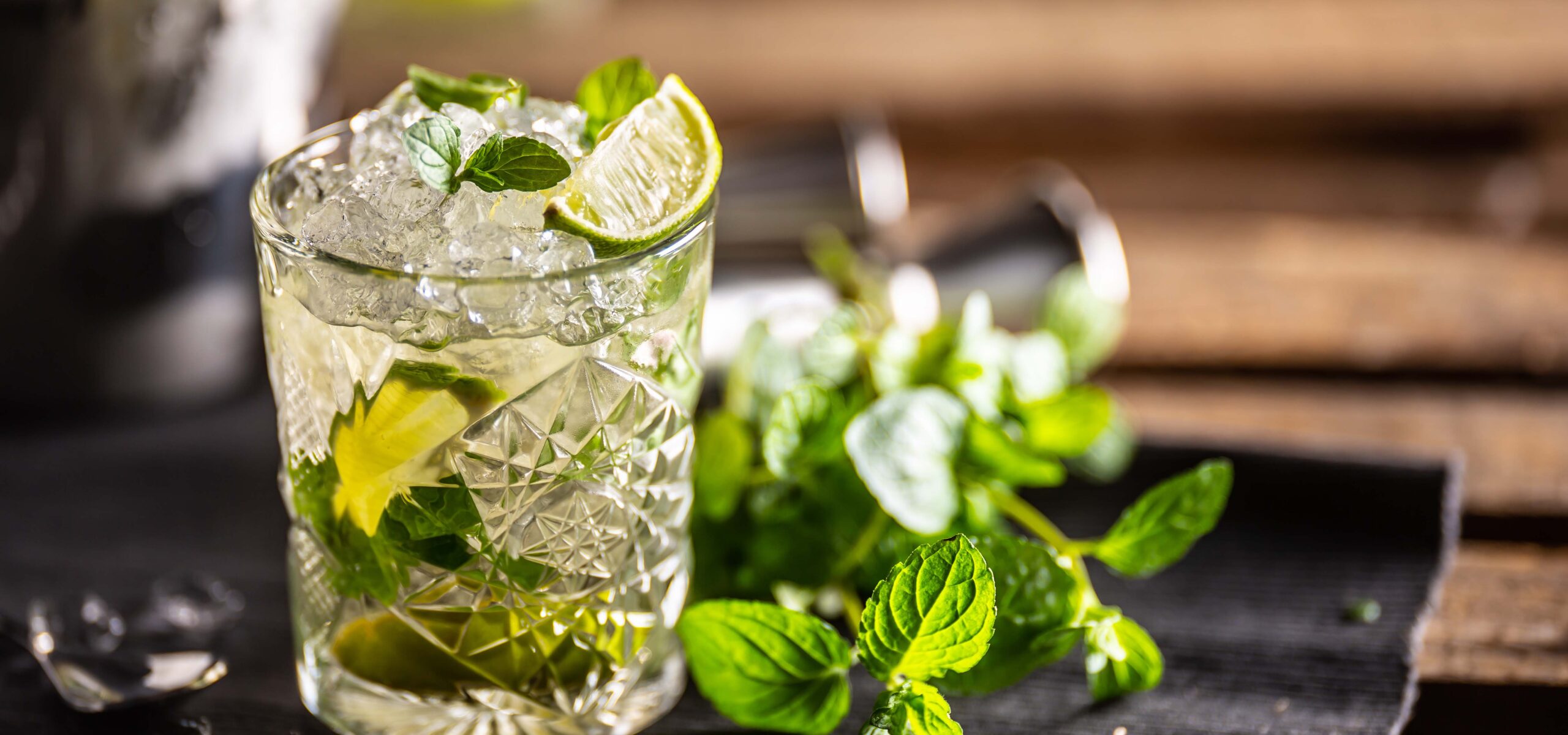 Glass filled with a mojito mix and limes. with mint on the side.