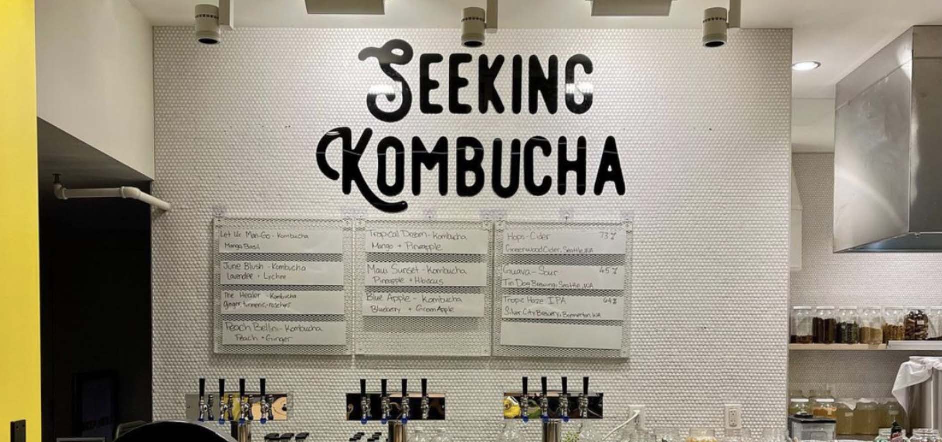 Kombucha shop menu board with taps below.
