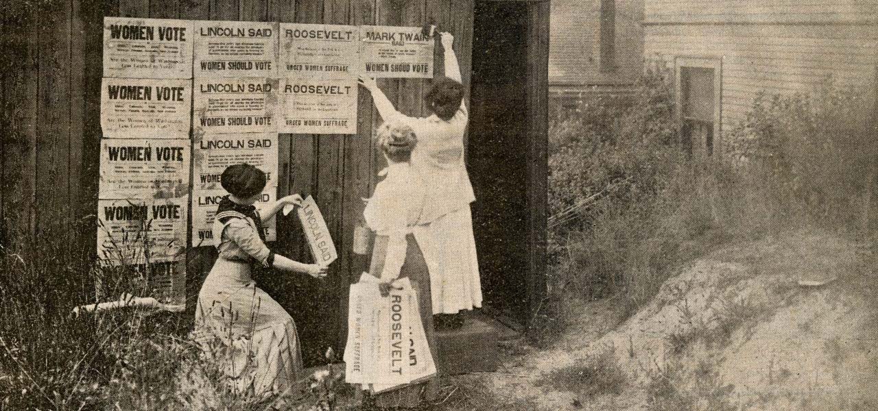 Women putting up voting signs during suffrage.